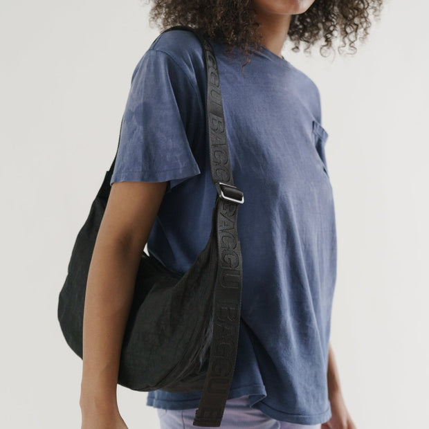 Baggu Medium Recycled Nylon Crescent Bag - Black worn over the shoulder