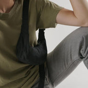 Woman wears Baggu Mini Recycled Nylon Crescent Bag - Black over her shoulder