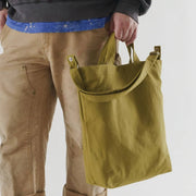 Man holding a Baggu Duck Tote- Spanish Olive